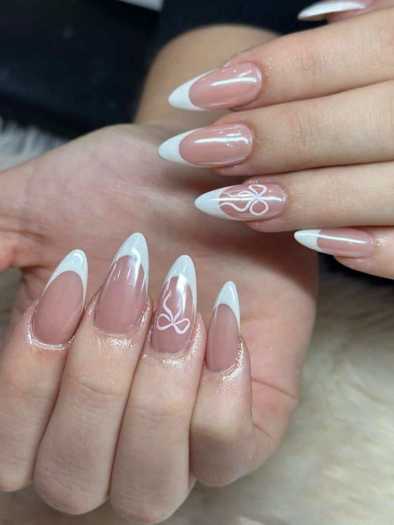 Nude amandelnagels met witte French tips en witte strikjes